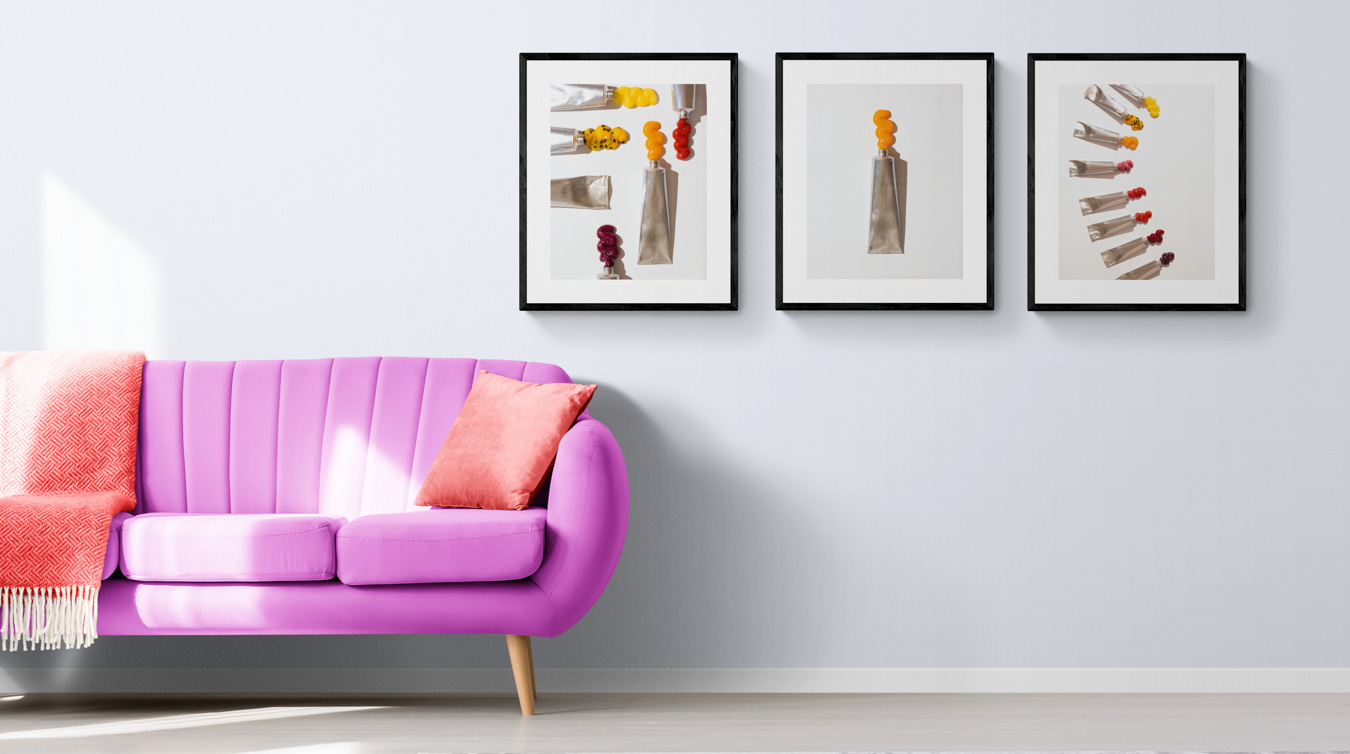 Purple sofa with orange cushion, 3 colourful food prints on wall